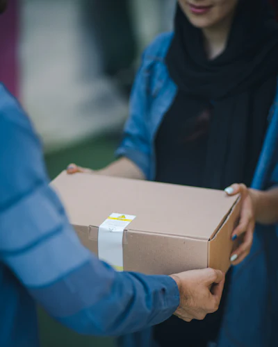 A parcel being handed from one person to another